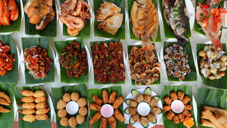Flat lay of a variety of local Halal dishes laid on banana leaves