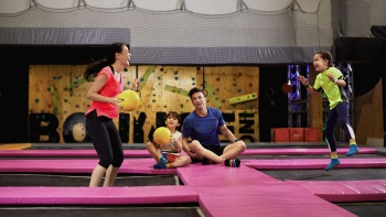 Interior action shot of family playing ball at Bounce Singapore