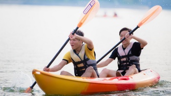 Two boys having fun while kayaking on the water