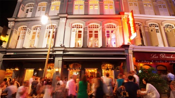 A bustling street on Ann Siang road, with a night view of shophouse facades and bars shot from ground level