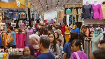 Candid shot of crowds of people perusing various clothing stalls in the air-conditioned tent area at Geylang Serai Ramadan Bazaar.