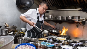 A chef cooking in the kitchen of Kok Sen Restaurant