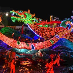 A float parading past audiences at a Chingay Parade at night