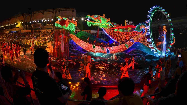 A float parading past audiences at a Chingay Parade at night