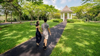 Pasangan muda berjalan menyusuri Singapore Botanic Gardens