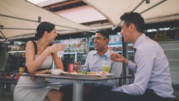 Sekelompok teman dari berbagai ras bersantap bersama di pusat jajanan kuliner