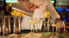 Bartender menuangkan koktail ke gelas.