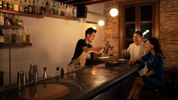 Pasangan dewasa aktif bersama bartender di bar Native