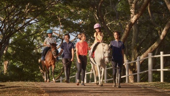 Ibu dan anaknya menunggangi kuda poni di Gallop Stable di cabang Pasir Ris Park