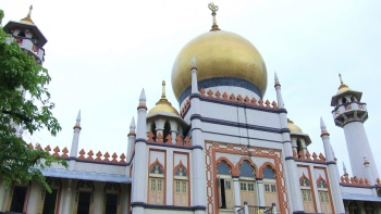Foto jarak dekat arsitektural kubah dan menara di Sultan Mosque. 