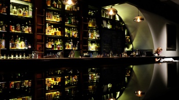Konter bar dan rak jajaran minuman beralkohol yang dipamerkan di 28 HongKong Street