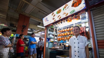 Chef Chan Hong Meng berdiri di depan Liao Fan Hong Kong Soya Sauce Chicken Rice and Noodle