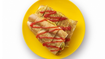 Sepiring Roti John (setengah potong roti Prancis goreng dengan taburan daging kambing cincang, irisan bawang, dan telur).