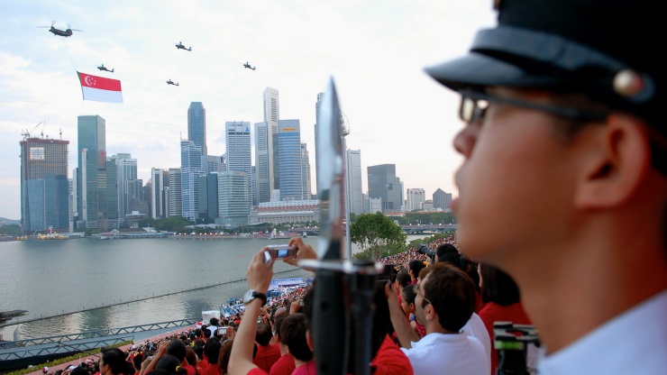 Penonton menyaksikan parade pesawat terbang National Day Parade