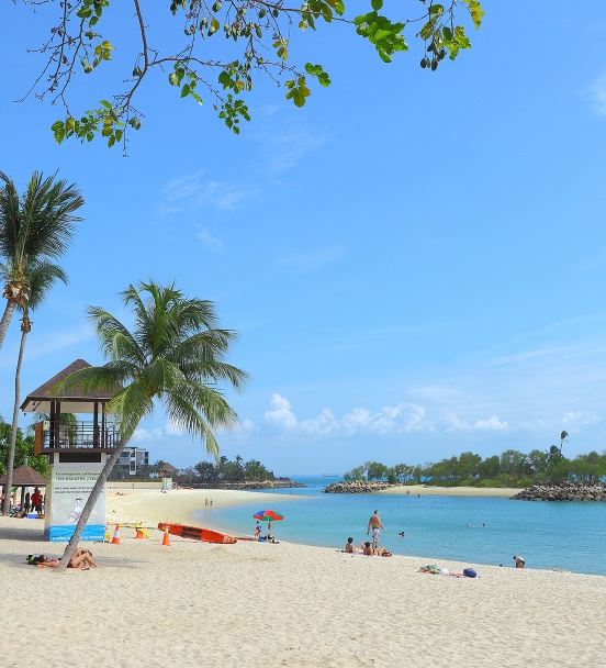 Pencinta pantai bermain di pantai dan laut di Sentosa.