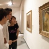 Foto pengunjung mengelilingi koleksi karya seni yang dipajang di Old Parliament House