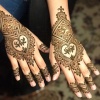 Tangan yang dihias dengan pola henna atau inai oleh studio henna SyraSkins.