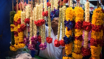Untaian bunga tradisional tergantung di depan toko untuk dijual