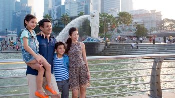 Foto pengunjung yang mengambil gambar berlatarkan Merlion kala malam