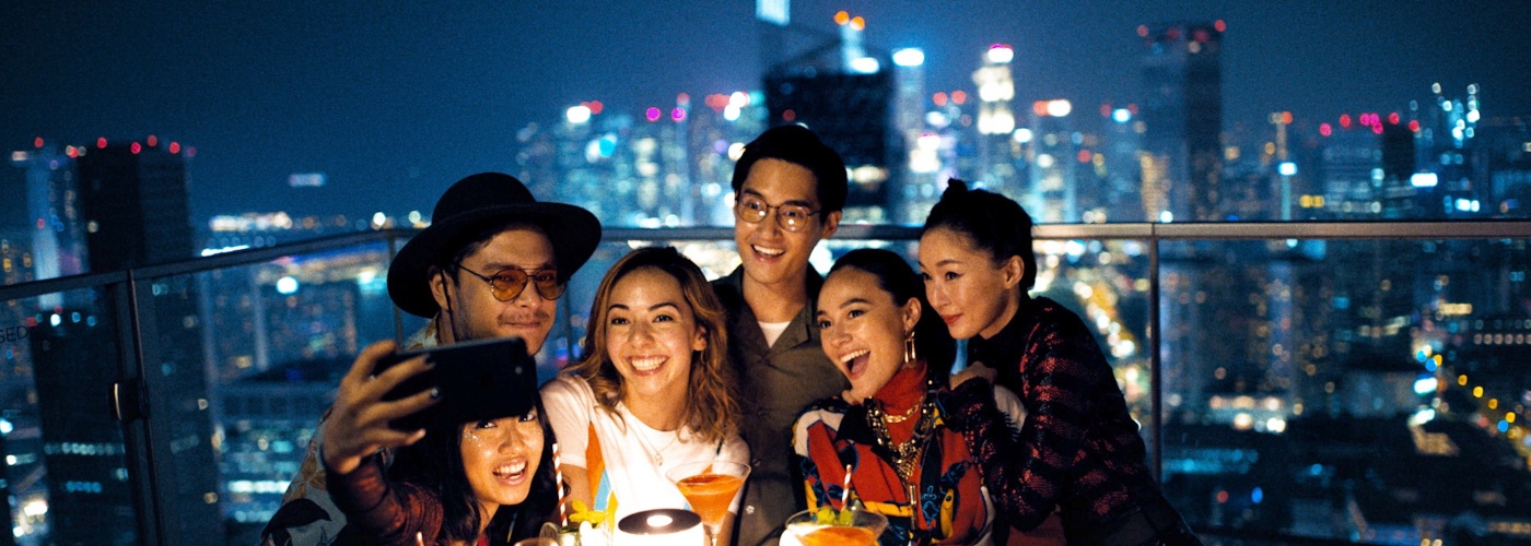 A group of friends taking a selfie together atop a bar