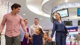 Keluarga yang terdiri dari lima orang dengan koper mereka menyusuri lobi Singapore Cruise Center