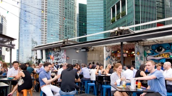 Pemandangan siang hari di luar ruangan saat orang-orang menyesap minuman di kinki Restaurant + Bar Collyer Quay