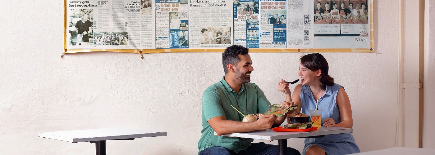 Couple enjoying a bowl of Katong laksa outdoors