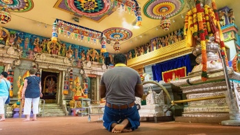 寺院で祈りを捧げている男性