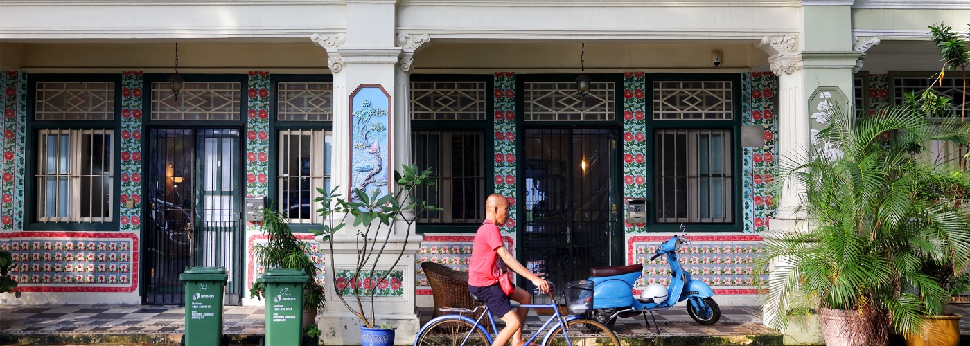 Man cycling past heritage shophouses at Jalan Besar, Singapore