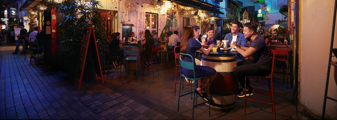 ハジ・レーンの「Blu Jaz Café（ブルー・ジャズ・カフェ）」のテラス席で楽しい夜のひとときを過ごすネイサン・ハルトノと仲間たち