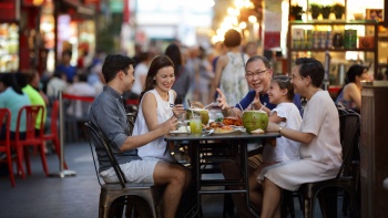 シンガポールのチャイナタウン・フード・ストリートで食事を楽しむ家族連れ