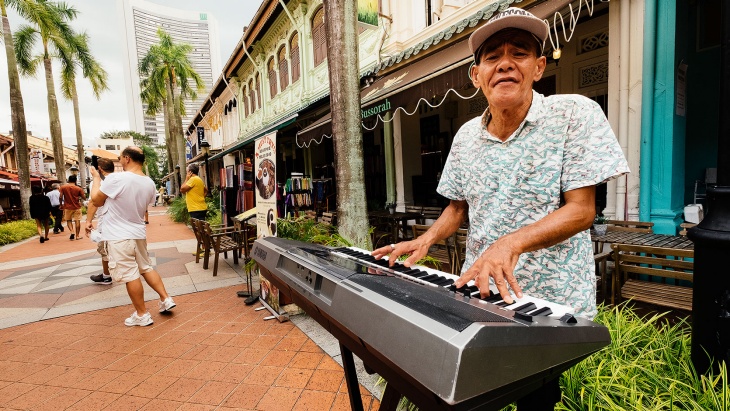 싱가포르 거리에서 전자 키보드를 연주하는 노인.