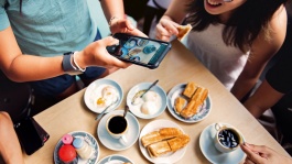 카야 토스트, 코피, 반숙 달걀을 즐기는 전통 싱가포르식 아침 식사를 즐기고 있는 사람들