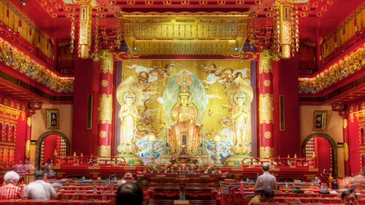 A statue of the Buddha surrounded by a grand interior