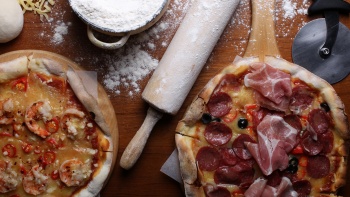 A flatlay of pizzas and baking tools from The Coastal Settlement.
