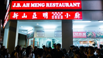 A group of people outside JB Ah Meng, a zi char restaurant along Geylang Lorong 30.