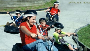A family go-carting at Skyline Luge. 