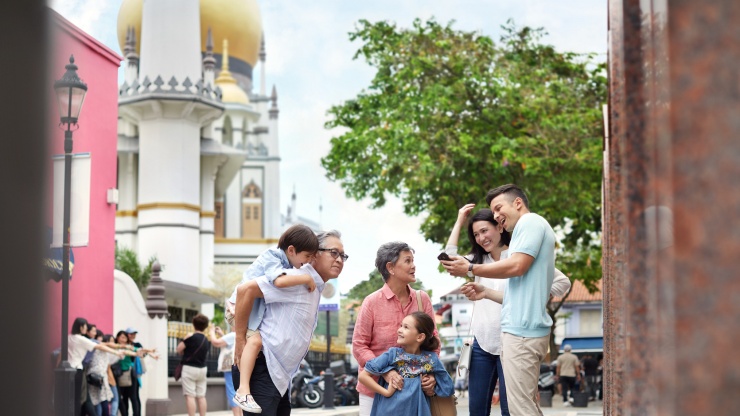 Family with active silvers and Sultan Mosque in the background