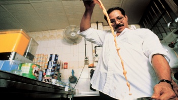 Indian man making teh tarik