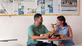 Couple enjoying a bowl of Katong laksa outdoors