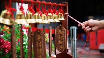 ผู้มาสักการะสิ่งศักดิ์สิทธิ์ มาสั่นกระดิ่งเพื่อขอพรที่ Thian Hock Keng Temple (วัดเทียนฮกเก๋ง) ในสิงคโปร์