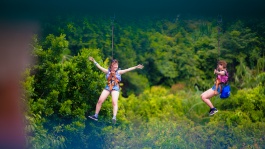 หญิงสาวสองคนกำลังจะโหนซิปไลน์ที่ Mega Adventure ของ Sentosa