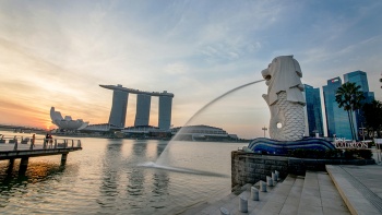 Merlion (เมอร์ไลออน) พ่นน้ำลงในแม่น้ำท่ามกลางบรรยากาศยามเย็น