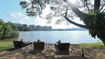 ผู้คนกำลังนั่งพักผ่อนคลายกันที่ Lakeside Promenade ใน Jurong Lake Gardens