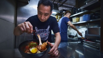 ภาพวาดเจ้าของร้าน A Noodle Story กำลังปรุงบะหมี่หมูแดง