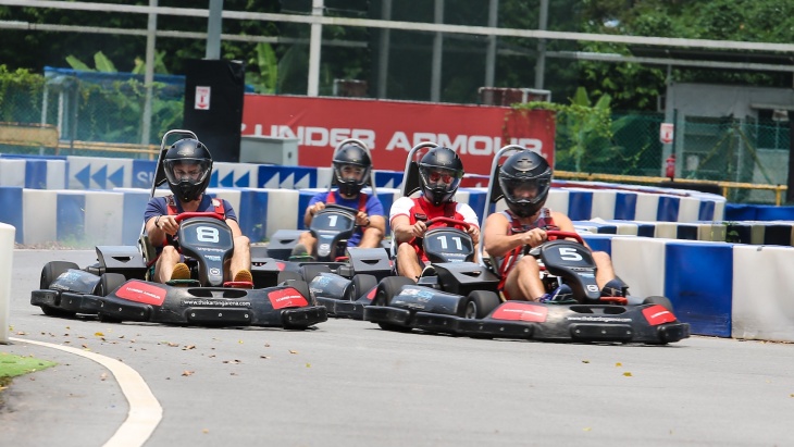 นักแข่งรถ 4 คนกำลังหักเลี้ยวรถในสนาม The Karting Arena