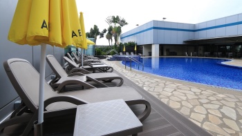 ร่มกันแดดสีเหลืองริมสระว่ายน้ำกลางแจ้งของโรงแรม Aerotel