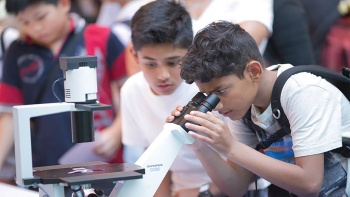เด็กๆ กำลังส่องกล้องจุลทรรศน์ที่งาน Singapore Science Festival ซึ่งจัดขึ้นที่ Singapore Science Centre (ศูนย์วิทยาศาสตร์สิงคโปร์)