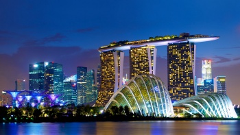 วิวในตอนกลางคืนของ Marina Bay Sands และเรือนกระจก Cloud Forest (คลาวด์ฟลอเรสต์) และ Flower Dome (ฟลาวเวอร์โดม) ซึ่งเป็นวิวจาก Marina Bay East Gardens