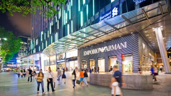 นักช้อปนอกร้าน Emporio Armani ที่ศูนย์การค้า Mandarin Gallery ในยามค่ำ